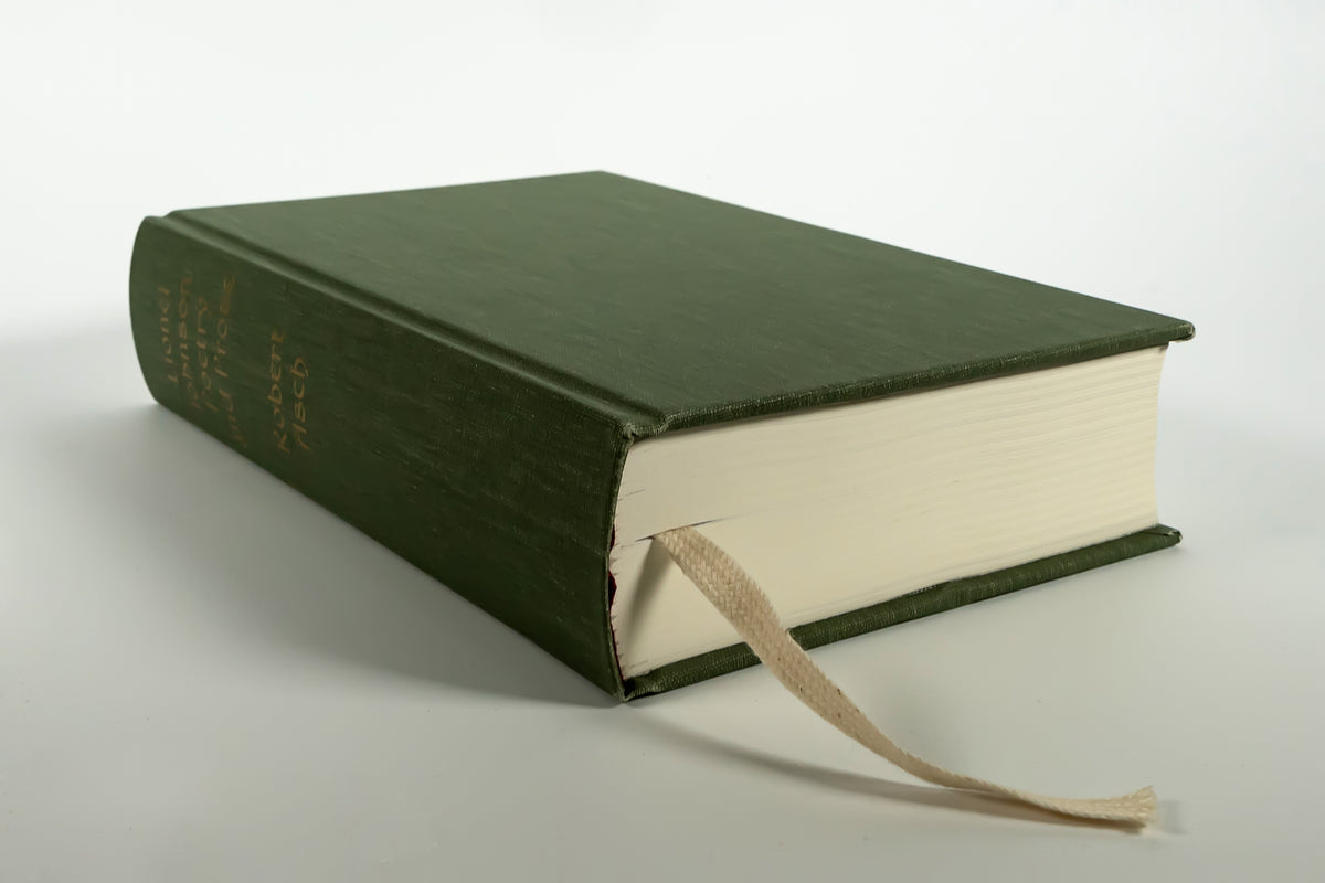 The green cloth binding of Lionel Johnson: Poetry and Prose lying flat, ribbon marker showing